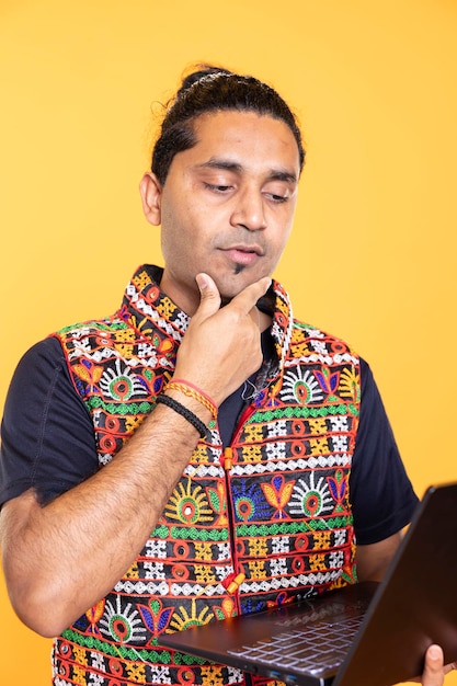 Free photo pensive man thinking how to solve business tasks on laptop