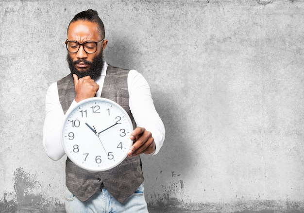 Pensive man with tie looking at a clock