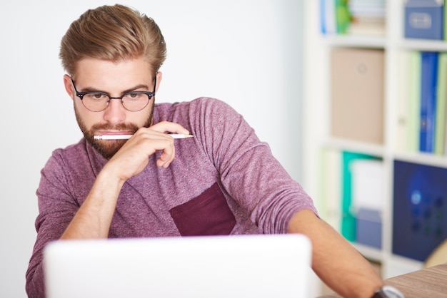 Free Photo pensive man working on laptop