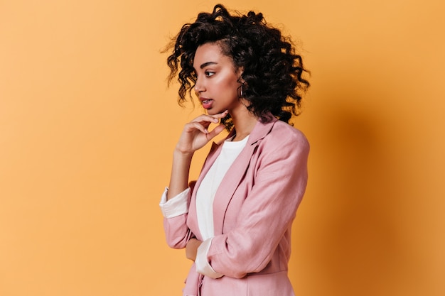 Free photo pensive sensual woman posing on yellow wall