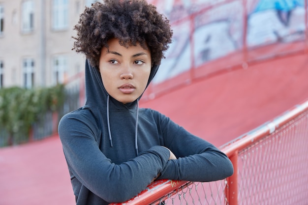 pensive sporty woman posing in outside setting