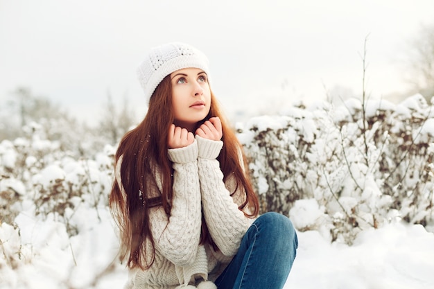 Free Photo pensive teenager sitting on snowy ground