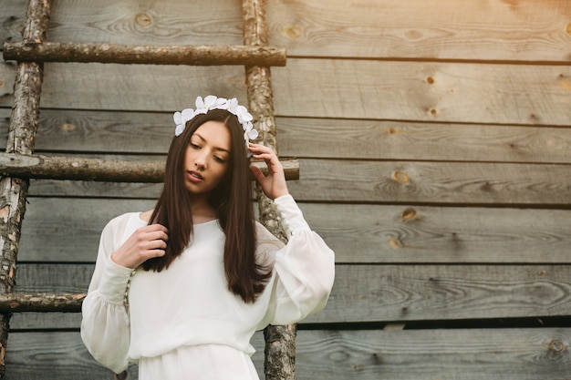 Pensive teenager with white flower wreath