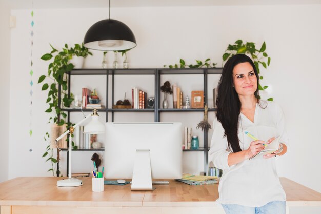 Pensive woman with workspace background