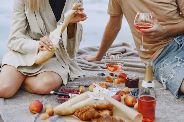 Free photo people by the river. delicious healthy summer picnic on the grass. fruits on a blancet.