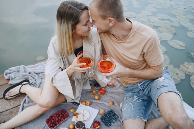 Free photo people by the river. delicious healthy summer picnic on the grass. fruits on a blancet.