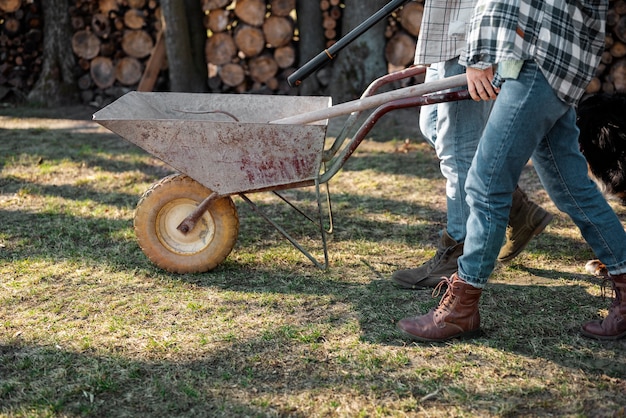 Free photo people carrying wheelbarrow rural life