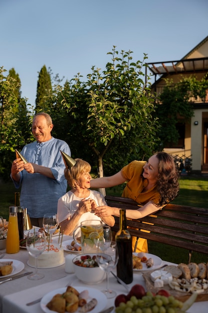 People celebrating a senior birthday party outdoors in the garden