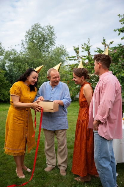 Free photo people celebrating a senior birthday party outdoors in the garden