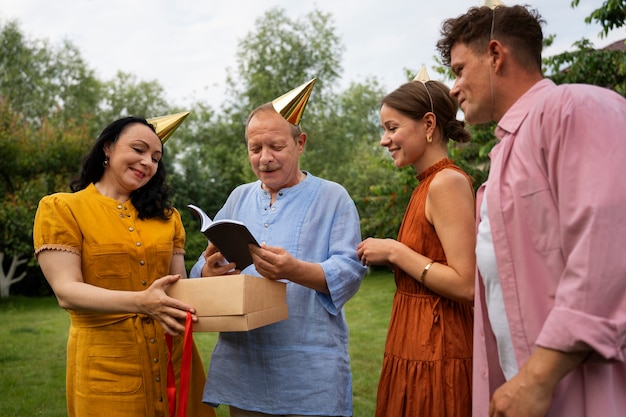 Free photo people celebrating a senior birthday party outdoors in the garden