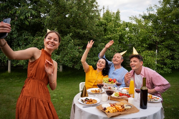 People celebrating a senior birthday party outdoors in the garden