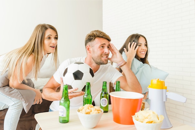 People cheering watching football match at home