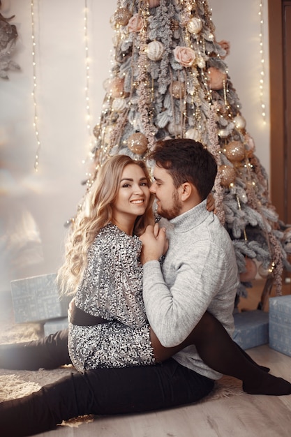 People in a Christmas decorations. Man in a gray sweater.