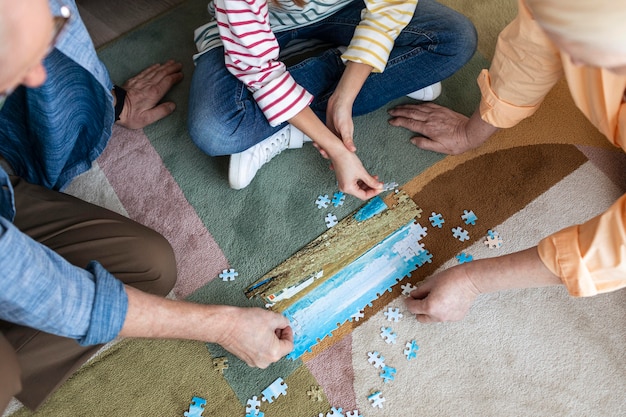 Free photo people doing puzzle on floor close up