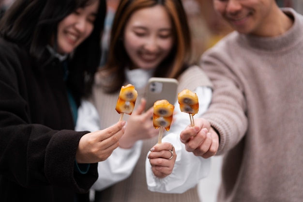 Free photo people enjoying japanese street food