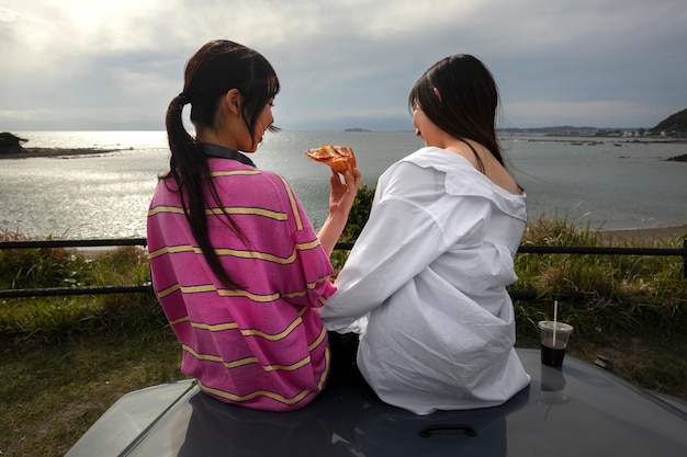 People enjoying pizza together outdoors