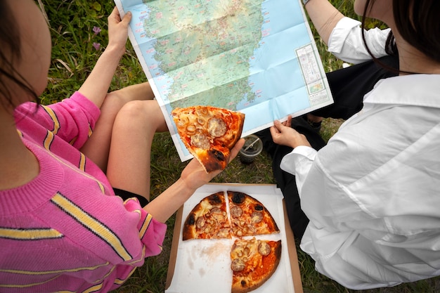 Free photo people enjoying pizza together outdoors