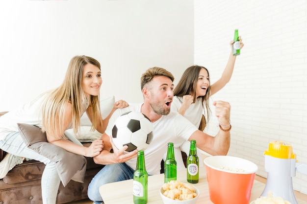 People happily shouting watching football at home