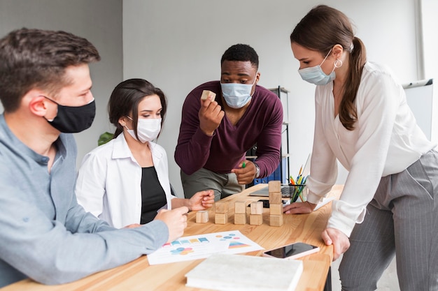 People having a meeting in the office with masks on during pandemic