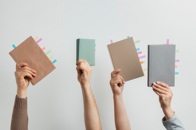 Free Photo people holding books with colorful reminders stickers