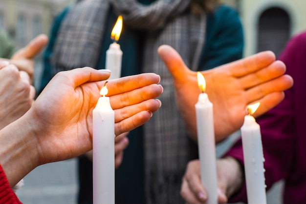 People holding candles side view