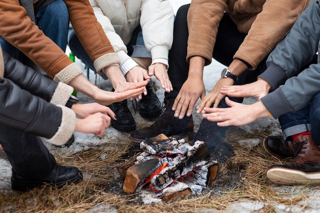 Free photo people holding hands by the fire