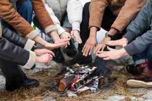 Free photo people holding hands by the fire