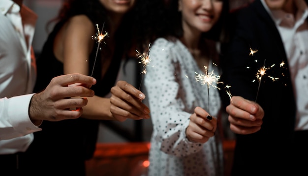 Free photo people holding sparklers at new year's eve party