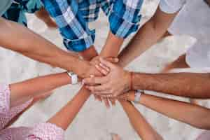 Free photo people joining hands together,group of friends keeping hands together.