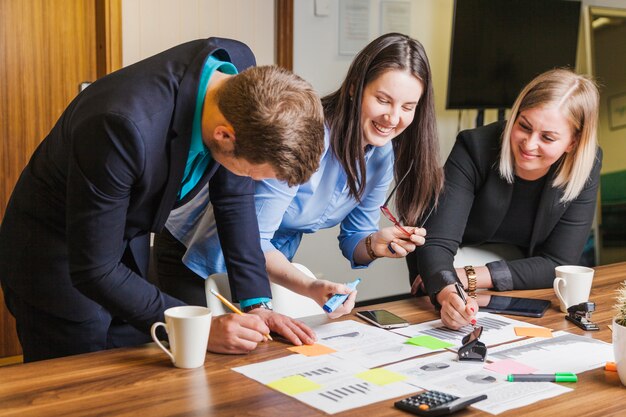 People leaning on desk standing smiling