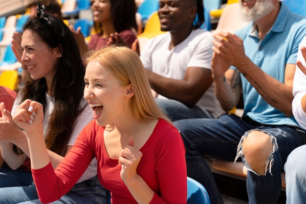 People looking at a football game in a sunny day