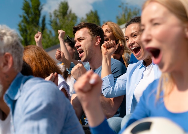 People looking at a football game in a sunny day