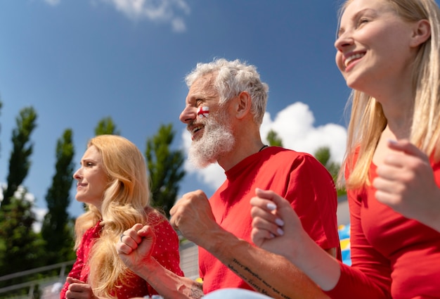 People looking together at a football game in a sunny day