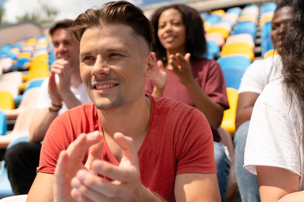 Free photo people looking together at a football game in a sunny day