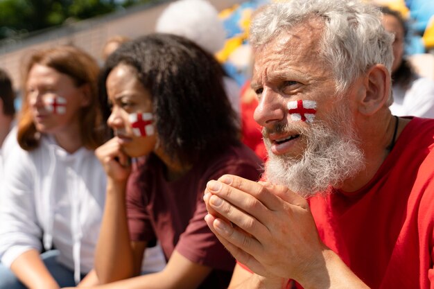 People looking together at a football game in a sunny day