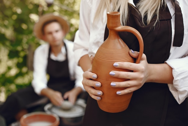 Free photo people making vases with clay