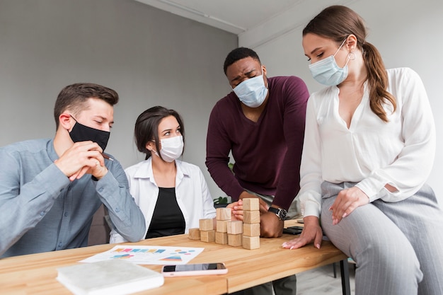 People in the office during pandemic having a meeting with medical masks on