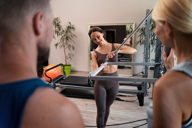 Free photo people in pilates reformer class exercising their bodies