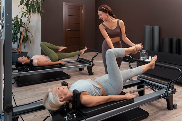 People in pilates reformer class exercising their bodies