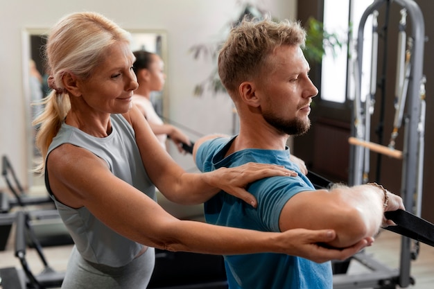 People in pilates reformer class exercising their bodies