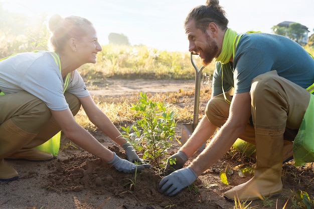 People planting tree on the countryside