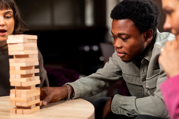 People playing a wooden tower game