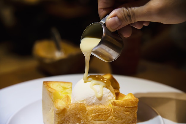 People pouring milk on ice cream bread toast 