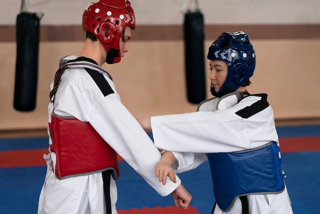 Free photo people practicing taekwondo in a gymnasium