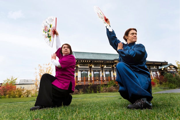 Free Photo people practicing tai chi full shot