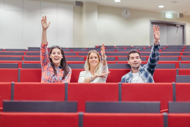 People raising hands at seminar