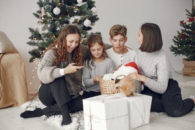 People reparing for Christmas. People sitting by the Christmass tree.