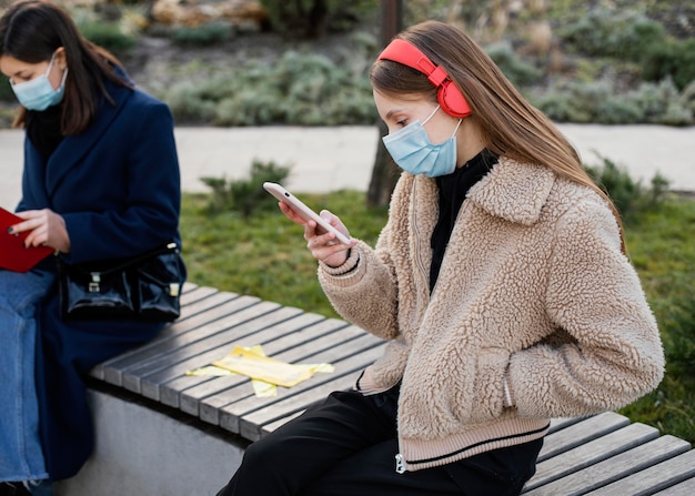 Free photo people sitting at distance and wearing mask