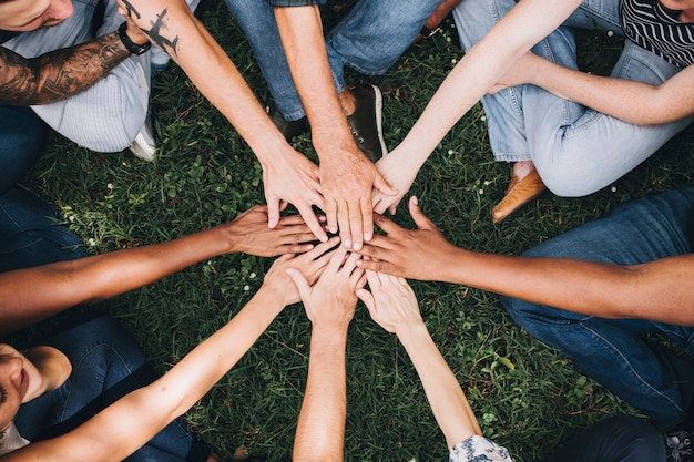 People stacking hands together in the park