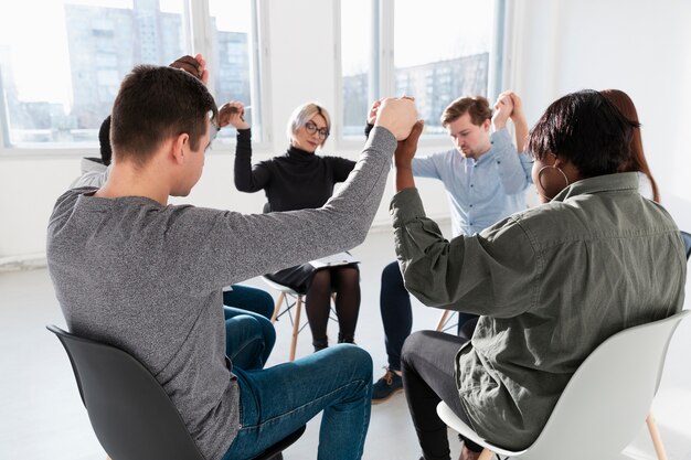 People standing with closed eyes and raising hands